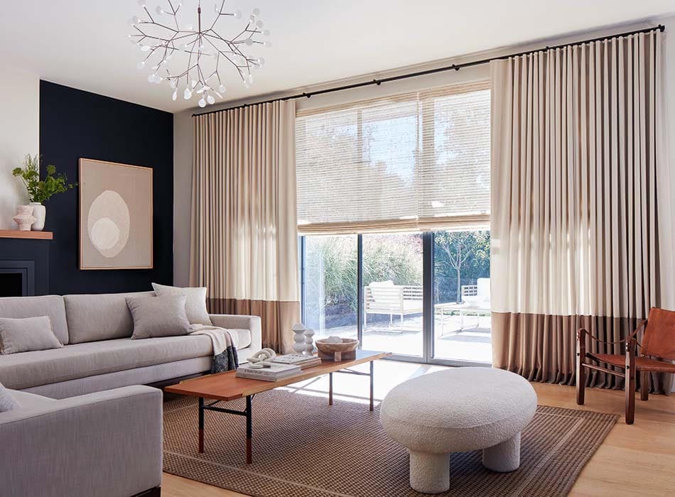 Dress curtains stacked either side of a slider with a woven shade doing the light control on the glass