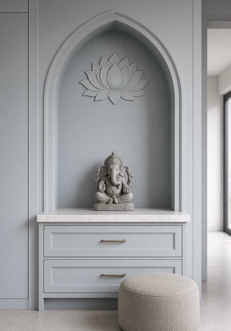 A pale arched niche with a lotus carved above it, a stone figure on the sill and two drawers below.