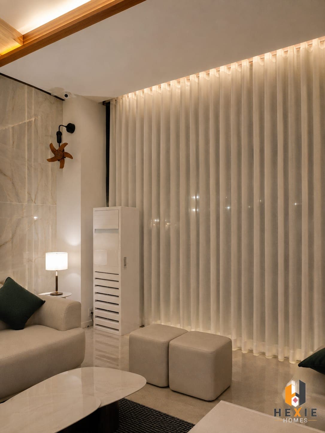 A full-height sheer curtain running the width of a lounge at Lore Resorts and Conventions, lit from a cove above so the folds read as vertical bands of light.
