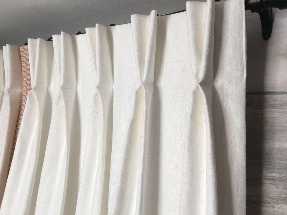 A pinch pleat heading in close-up, the fold shaped and stitched so it holds from the track to the floor